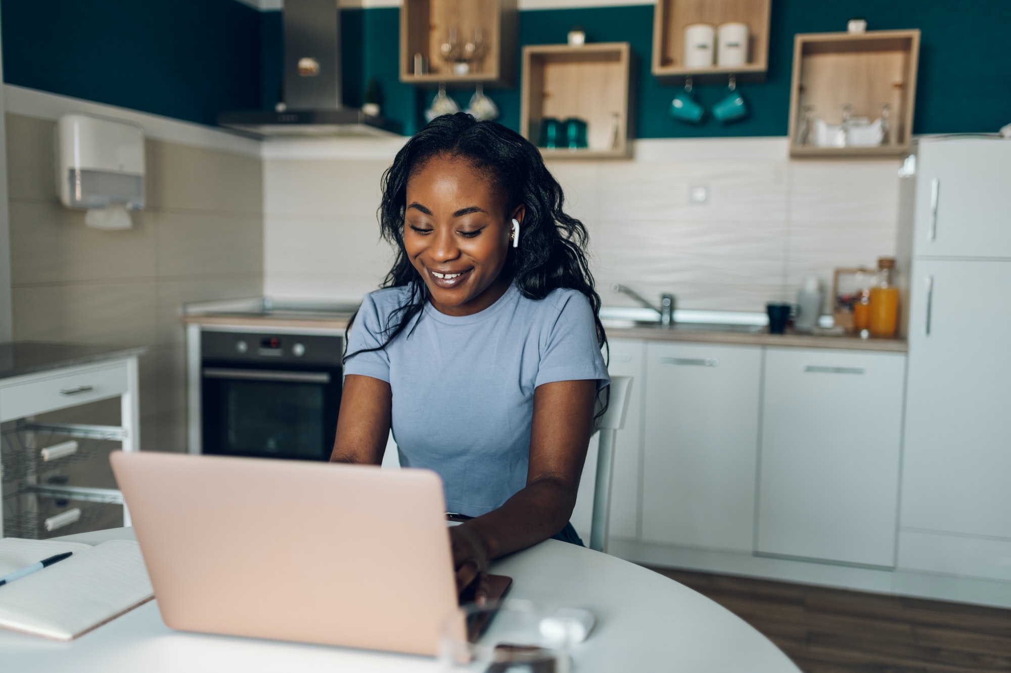 African american woman working from home while using a laptop