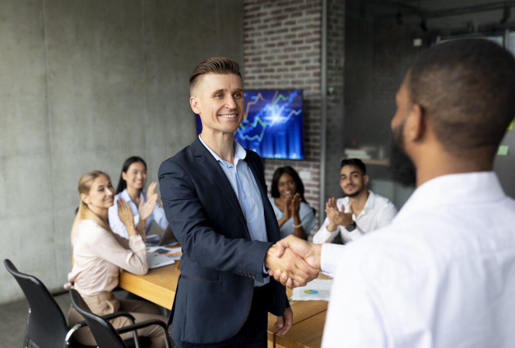 We're Hiring. Male HR Manager Handshaking With African American Employee In Office